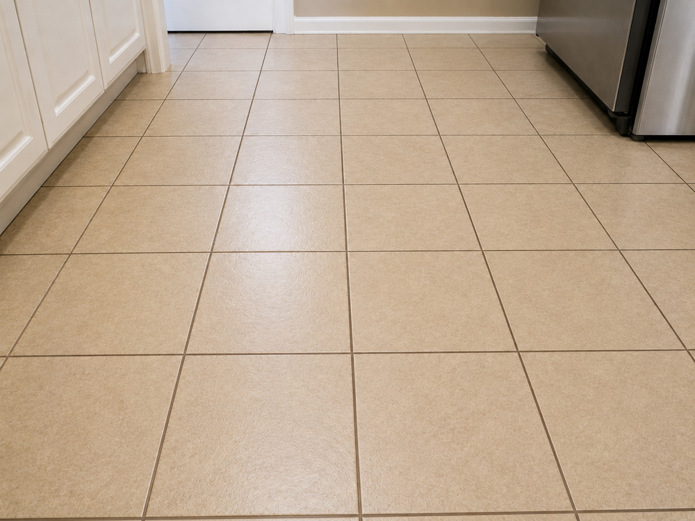 Kitchen floor grout with a new uniform color after professional color sealing